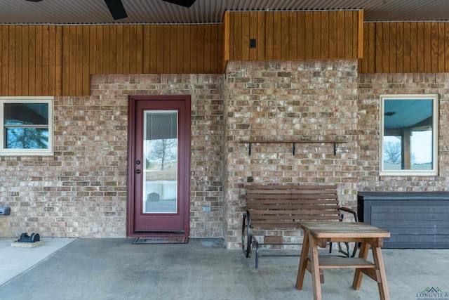 view of exterior entry featuring a patio area and ceiling fan