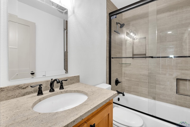 full bathroom featuring enclosed tub / shower combo, vanity, and toilet