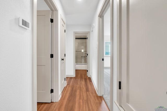 corridor with light hardwood / wood-style floors