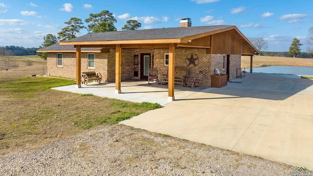 rear view of property with a patio and a lawn