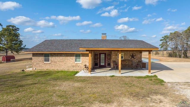 rear view of property featuring a patio area and a lawn