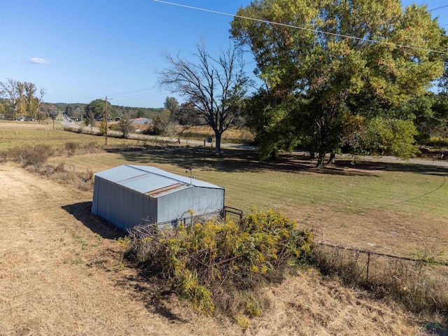 view of yard with a rural view and an outdoor structure