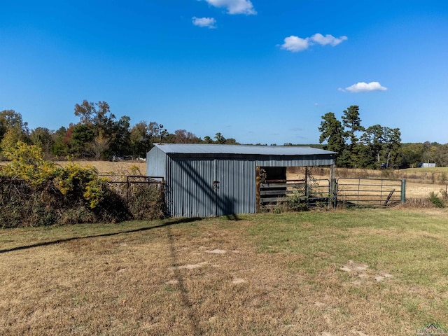 view of outdoor structure featuring a lawn and a rural view