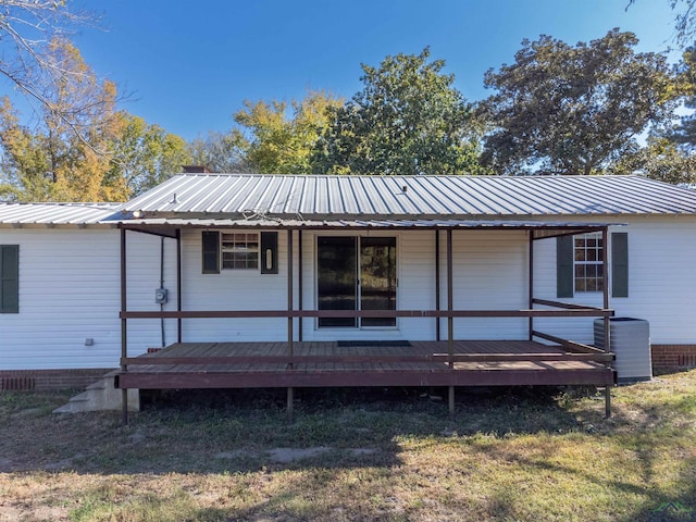 rear view of house featuring a yard and a wooden deck