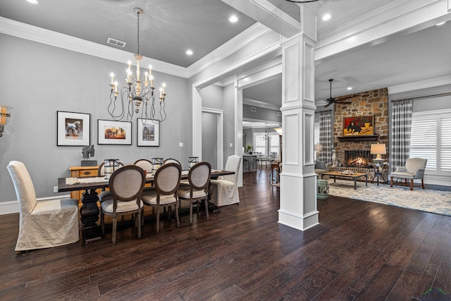 dining space with decorative columns, visible vents, hardwood / wood-style floors, a fireplace, and ceiling fan with notable chandelier