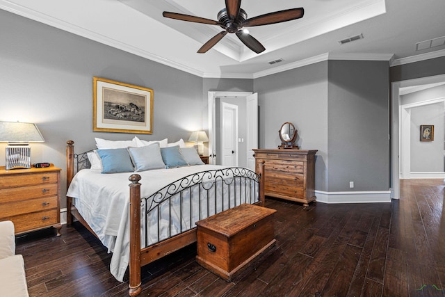 bedroom with visible vents, crown molding, a tray ceiling, and hardwood / wood-style floors