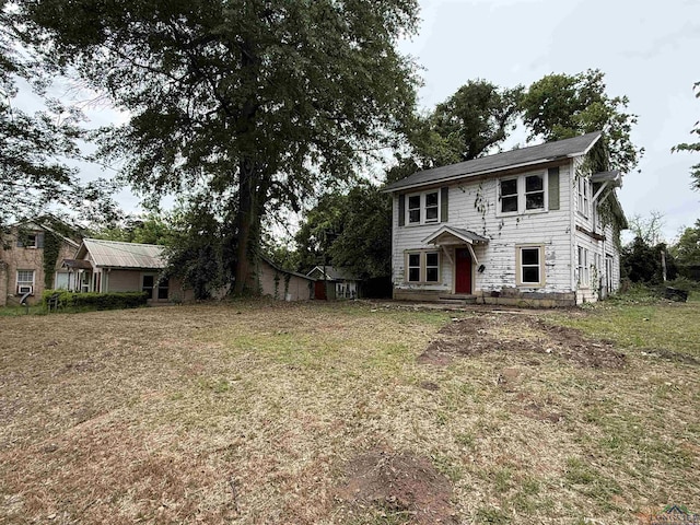 colonial-style house featuring a front lawn