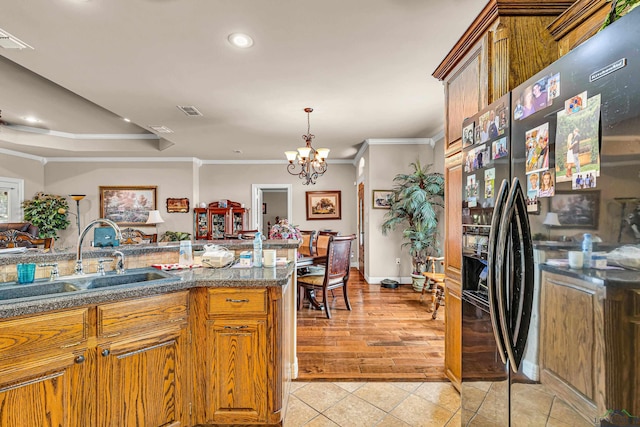 kitchen with crown molding, sink, fridge with ice dispenser, and a chandelier