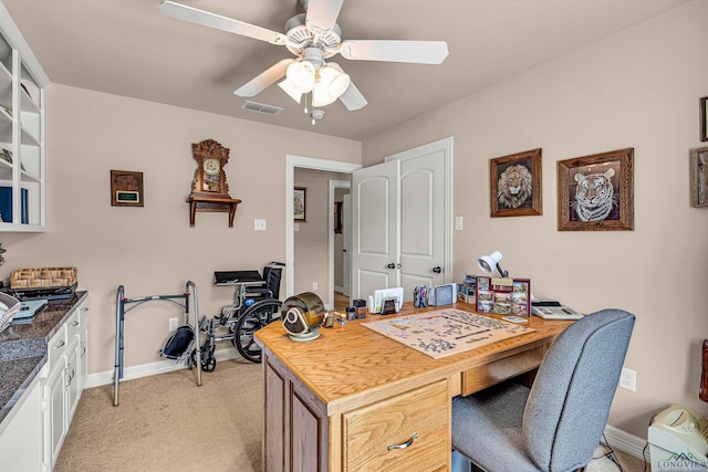 carpeted office space featuring ceiling fan