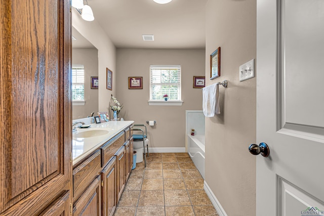 bathroom featuring tile patterned floors, vanity, toilet, and a tub