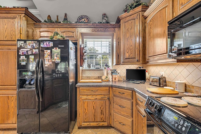 kitchen featuring decorative backsplash, light tile patterned flooring, and black appliances