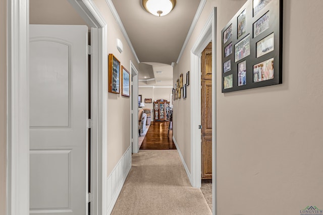 hallway featuring crown molding and light carpet