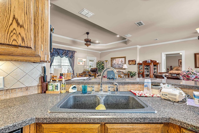 kitchen featuring tasteful backsplash, ceiling fan, ornamental molding, and sink