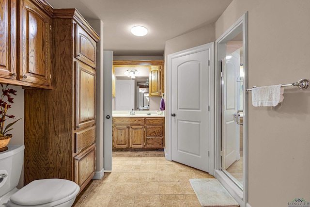 bathroom with vanity, toilet, and a shower with shower door