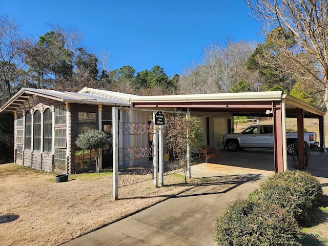 view of front of property with a sunroom and a carport