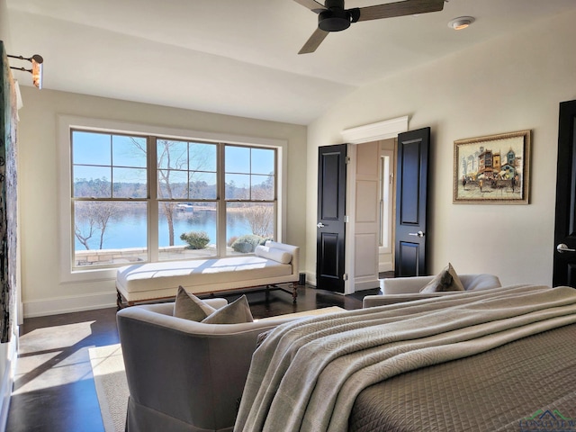 bedroom featuring vaulted ceiling, a water view, dark wood-type flooring, and ceiling fan