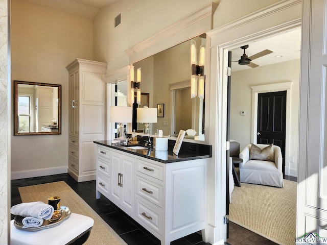 interior space with vanity, a towering ceiling, tile patterned floors, and ceiling fan