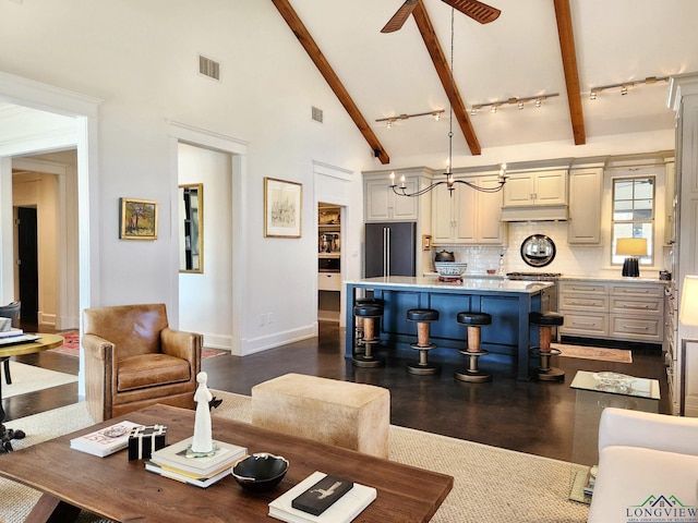 living room with beam ceiling, track lighting, high vaulted ceiling, and ceiling fan