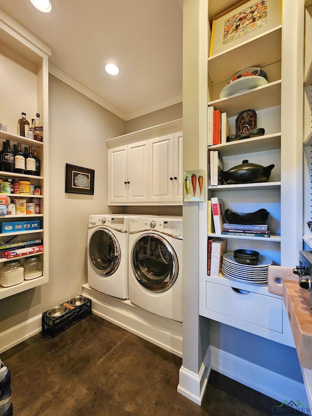 clothes washing area with crown molding, cabinets, and washer and dryer