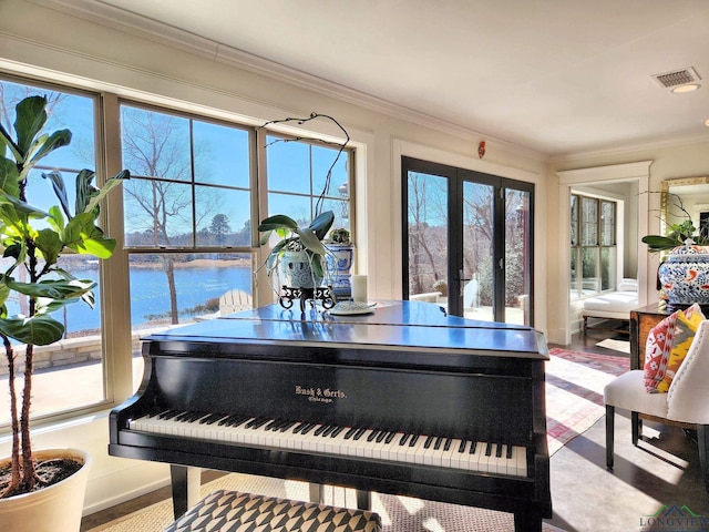 miscellaneous room featuring crown molding, plenty of natural light, french doors, and a water view