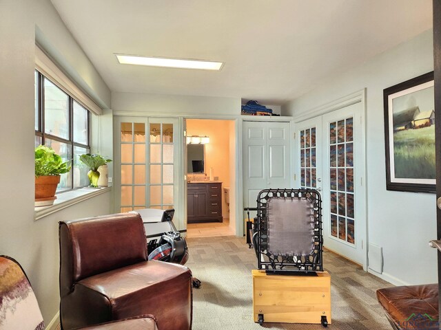 sitting room featuring light carpet and french doors