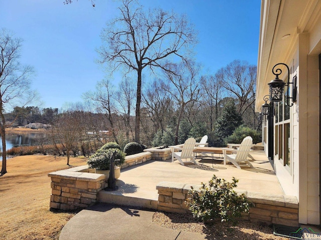 view of patio / terrace with a water view and a fire pit