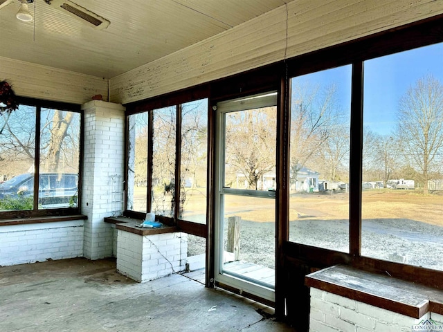 unfurnished sunroom featuring ceiling fan