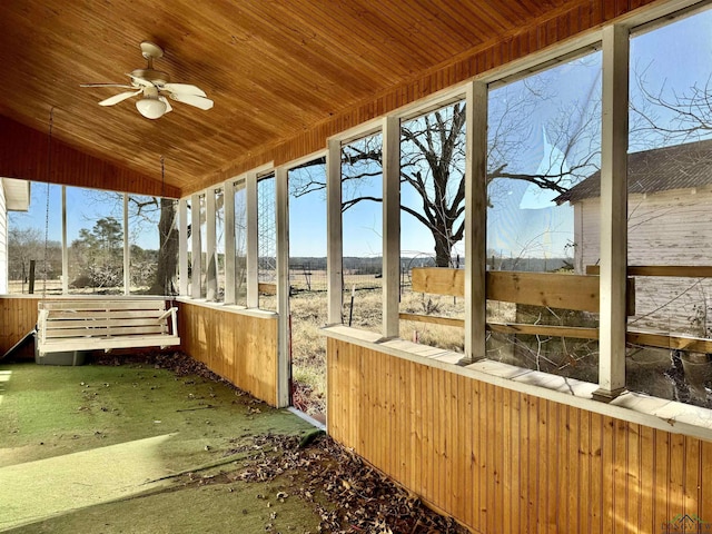 unfurnished sunroom with ceiling fan, vaulted ceiling, and a wealth of natural light