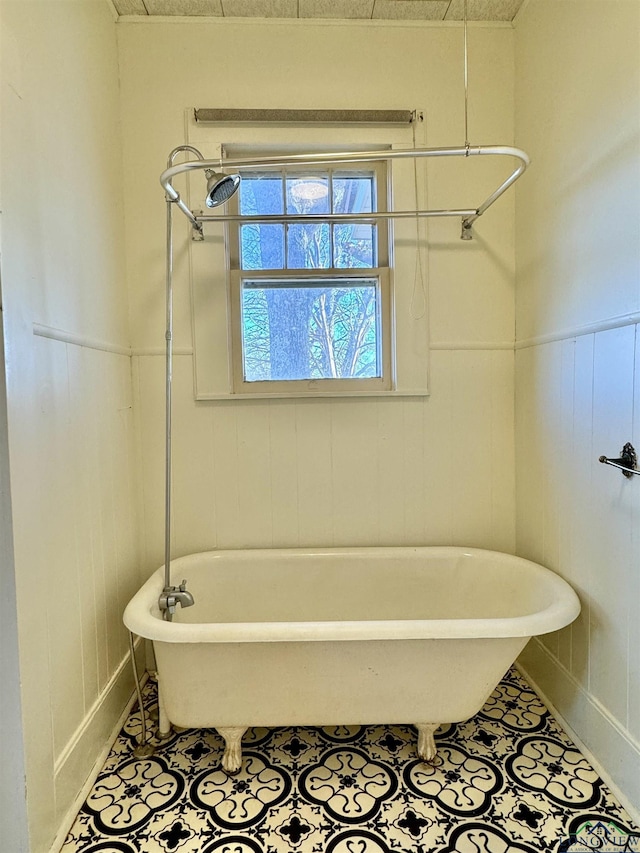 bathroom with a washtub and tile patterned floors