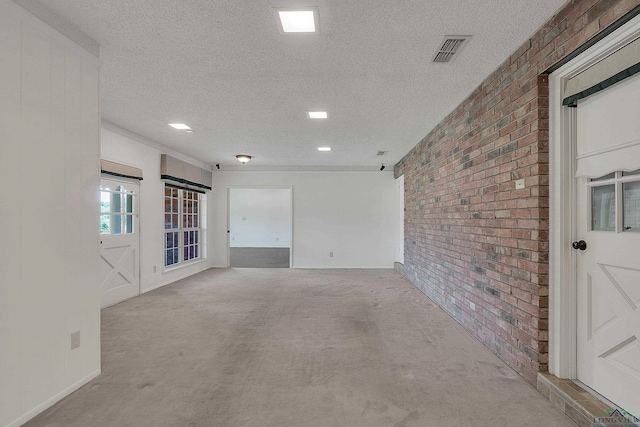 unfurnished room featuring light carpet, brick wall, and a textured ceiling