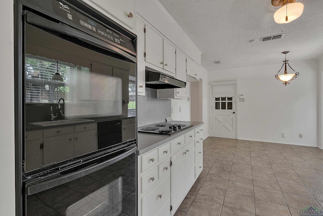 kitchen featuring white cabinetry, pendant lighting, stainless steel gas stovetop, black oven, and light tile patterned flooring