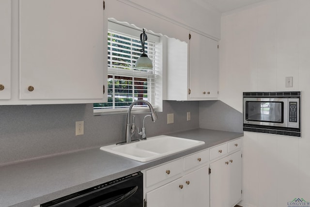 kitchen featuring decorative backsplash, sink, black dishwasher, white cabinetry, and stainless steel microwave