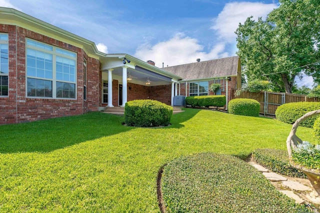 exterior space with central AC and a front yard