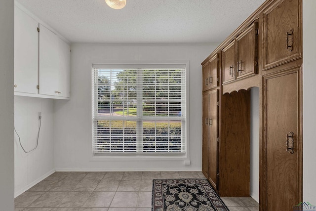 interior space with light tile patterned floors and a textured ceiling