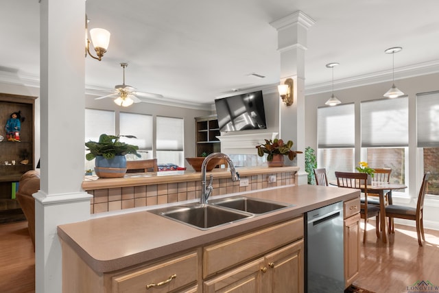 kitchen with a sink, decorative columns, dishwasher, and ornamental molding