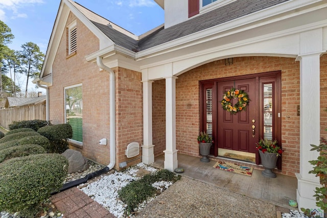 entrance to property featuring brick siding and covered porch