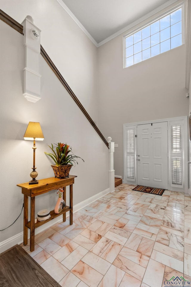 foyer with marble finish floor, stairway, a high ceiling, crown molding, and baseboards