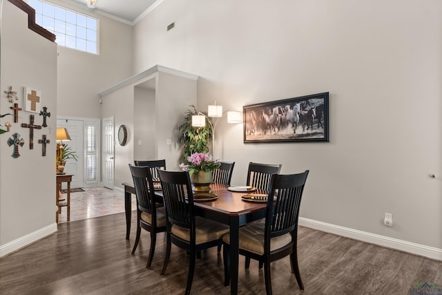 dining area with crown molding, wood finished floors, baseboards, and visible vents