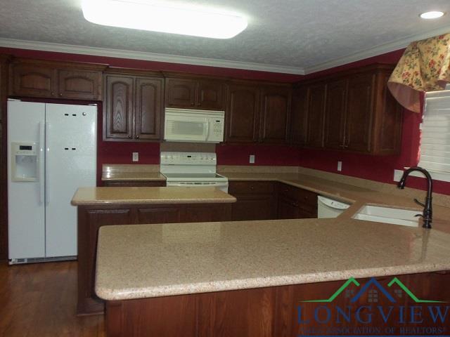 kitchen with a textured ceiling, crown molding, sink, and white appliances