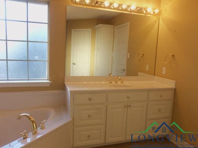 bathroom featuring a bathtub, a healthy amount of sunlight, and vanity