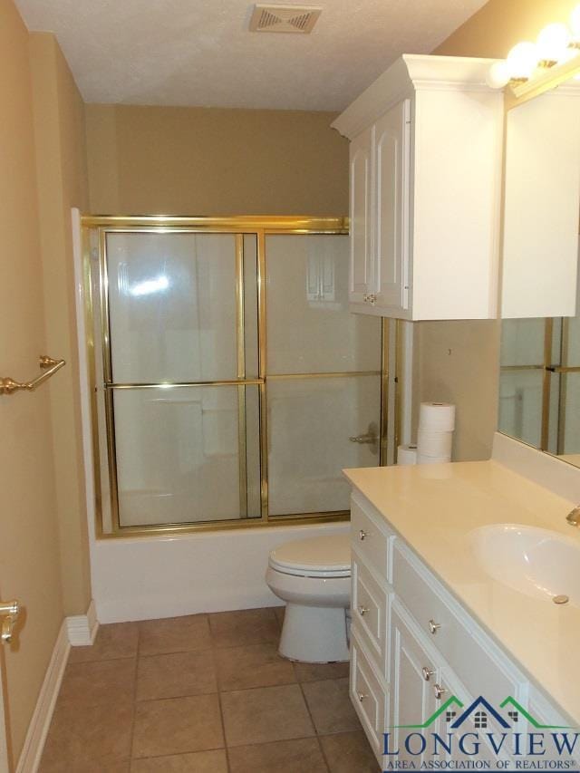 full bathroom with tile patterned flooring, toilet, combined bath / shower with glass door, and vanity