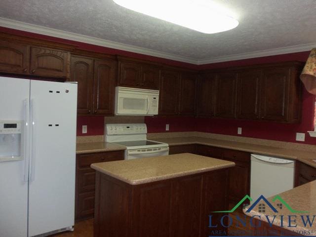 kitchen with ornamental molding, dark brown cabinets, a textured ceiling, white appliances, and a center island