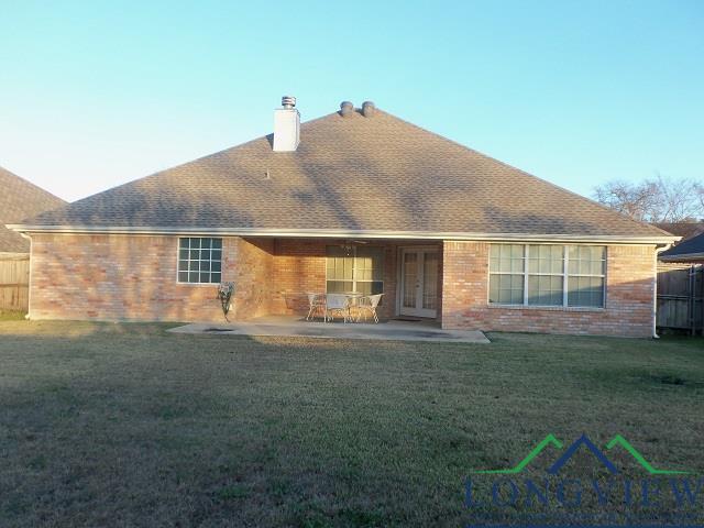 back of property with a patio area and a lawn