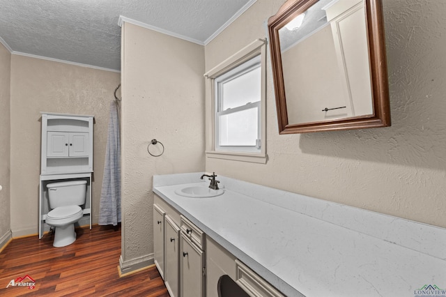 bathroom with wood-type flooring, a textured ceiling, toilet, and ornamental molding