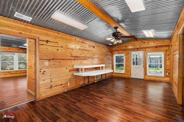 interior space featuring dark hardwood / wood-style floors, wood walls, ceiling fan, and lofted ceiling with beams