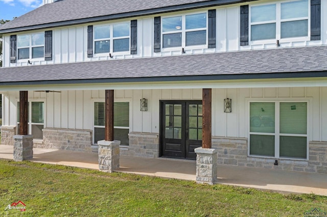 exterior space with french doors, stone siding, board and batten siding, and a shingled roof