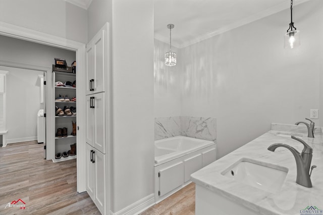 full bath with crown molding, wood finished floors, a tub, and a sink