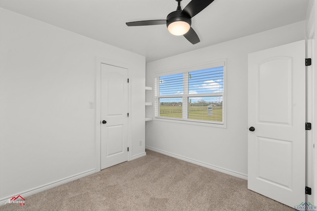 unfurnished bedroom featuring carpet flooring, a ceiling fan, and baseboards