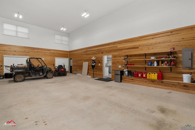 garage with electric panel and wood walls