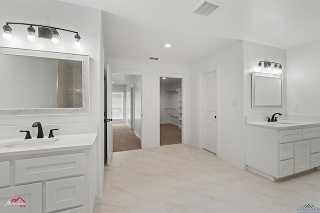 bathroom featuring a sink, visible vents, two vanities, and marble finish floor